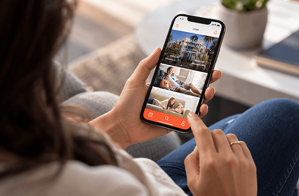 Hands holding a phone showing a hospitality app